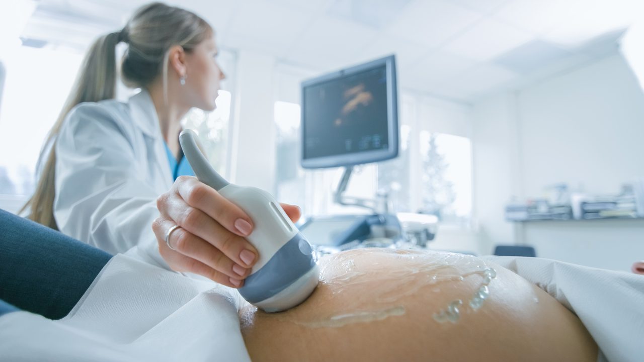 Ecografía ginecológica en proceso con transductor y gel en una paciente.